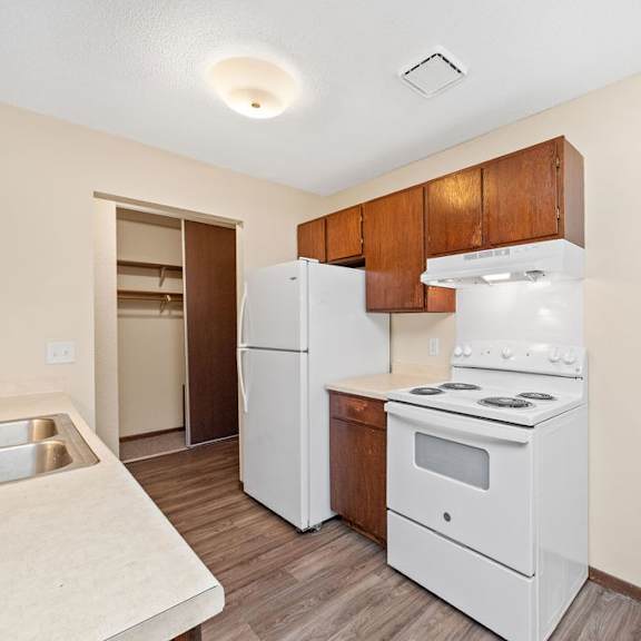 a kitchen with white appliances and wooden cabinets.