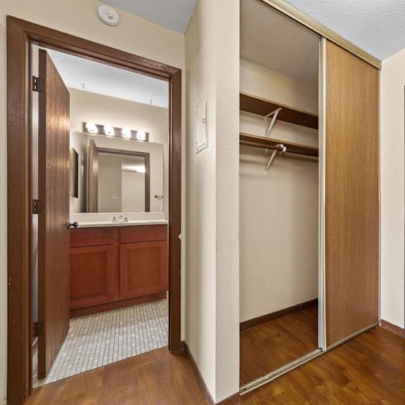 a wooden door is open to a bathroom with a mirror.