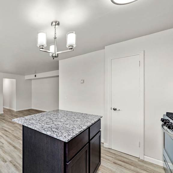 a kitchen with a granite countertop and a chandelier.