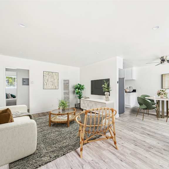a living room with a white couch, a wooden chair, and a television.