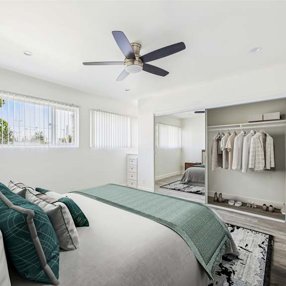 a bedroom with a bed, a ceiling fan, and a wardrobe.