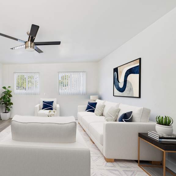 a living room with a white couch, a television, and a ceiling fan.