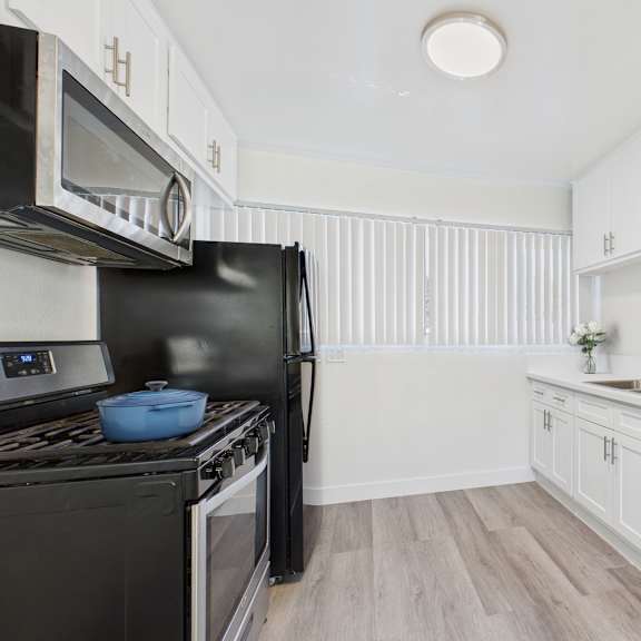 a kitchen with black appliances and white cabinets.