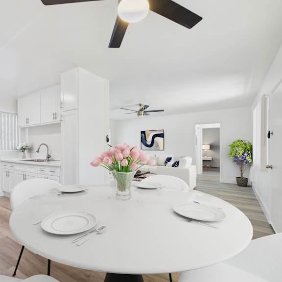 a dining room with a white table and chairs.
