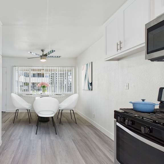a kitchen with white cabinets and a black stove top.