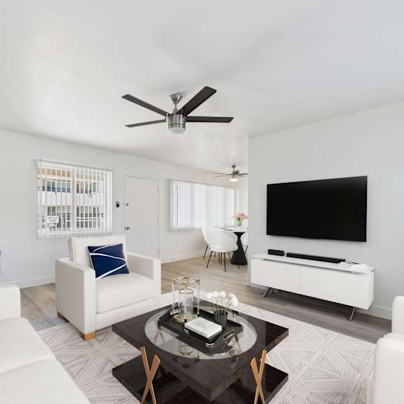 a living room with a white sofa, a coffee table, and a television.