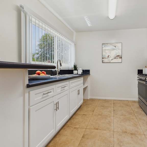 a kitchen with white cabinets and a black countertop.