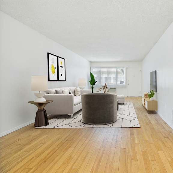 a living room with a white couch and a grey ottoman.