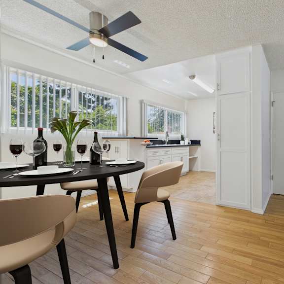 a modern dining room with a table set for two and a ceiling fan.