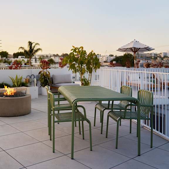 a patio with a table and chairs overlooking a city skyline.