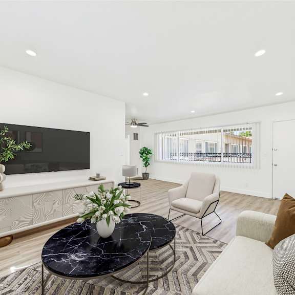 a living room with a black marble coffee table and a flat screen tv mounted on the wall.