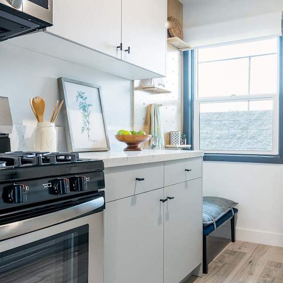a kitchen with a black stove top oven and white cabinets.