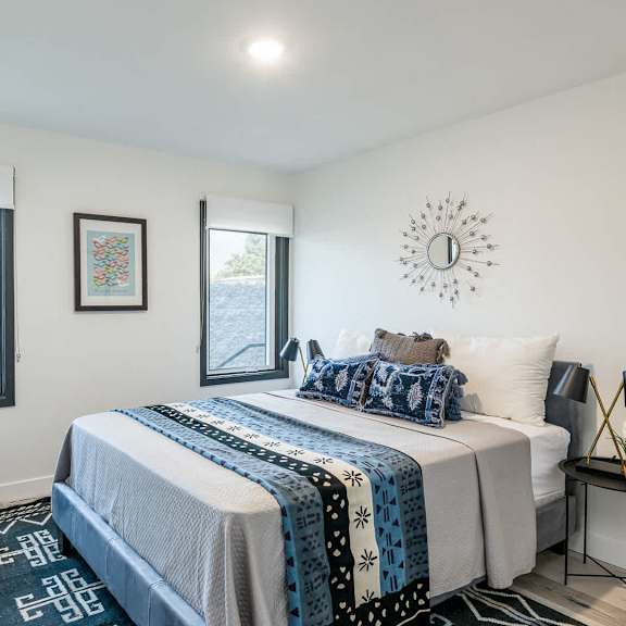 a bedroom with a large bed and a chair by the window.