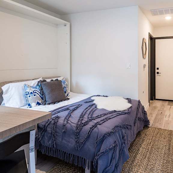 a bedroom with a bed covered in a blue blanket.