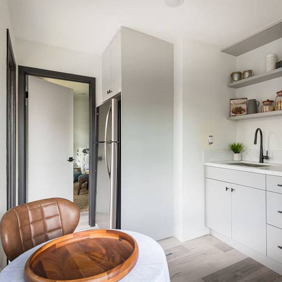 a modern kitchen with a wooden chair and a stove.