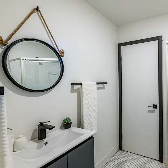 a bathroom with a white sink and a mirror above it.