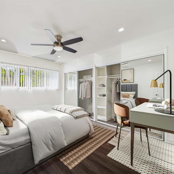 a bedroom with a bed, desk, and chair.