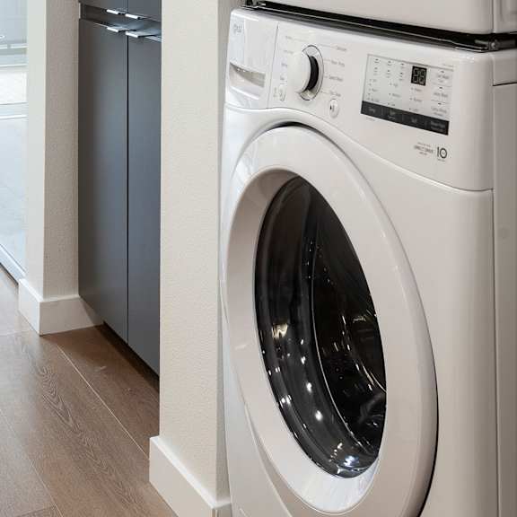 a white front load washing machine in a modern kitchen.