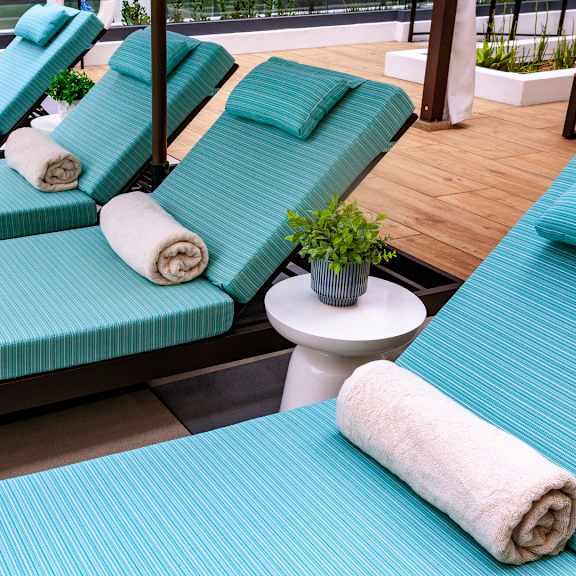 a set of four loungers with towels on them.