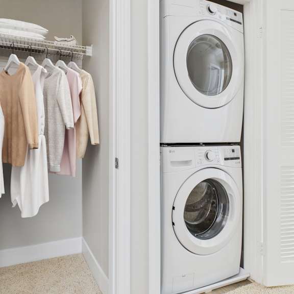 a white washing machine is in a laundry room.
