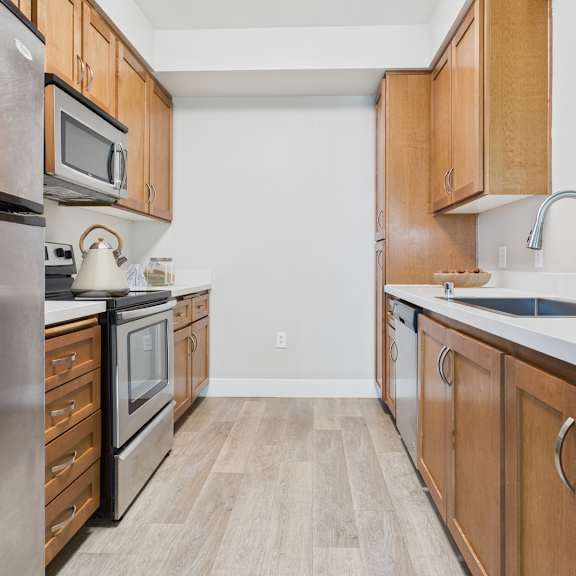 a kitchen with wooden cabinets and a stainless steel refrigerator.