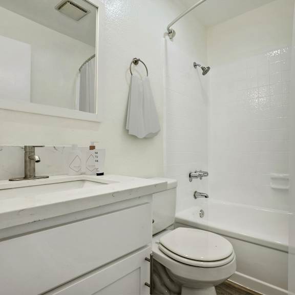 a white bathroom with a sink toilet and shower