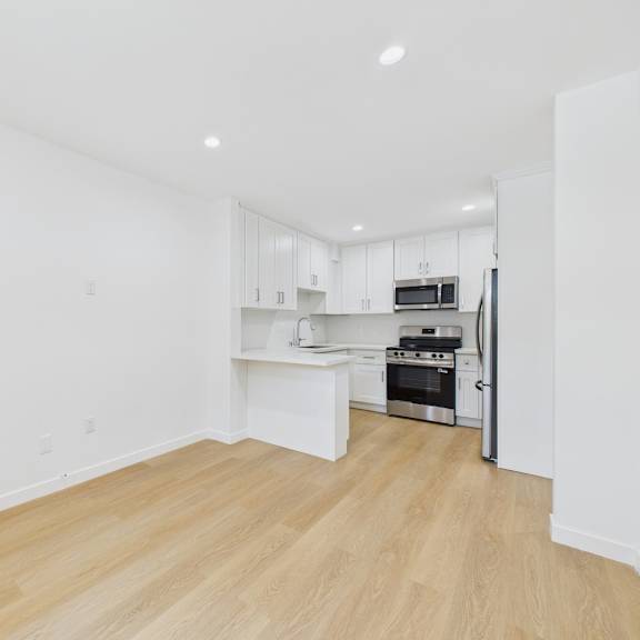 a kitchen with white cabinets and a microwave.