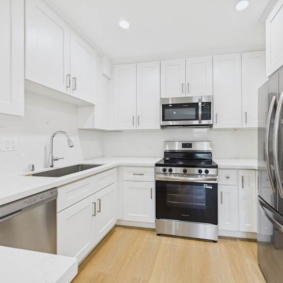 a modern kitchen with stainless steel appliances and white cabinets.