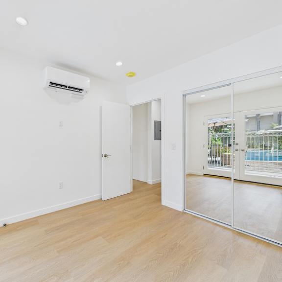 a room with a sliding glass door leading to a balcony.