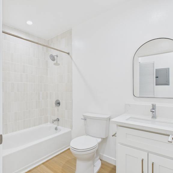 a white bathroom with a toilet, sink, and bathtub.