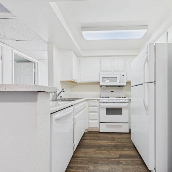 a white kitchen with a skylight above the counter.