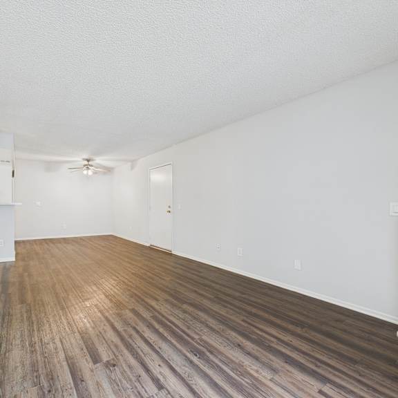 a room with wooden flooring and white walls.