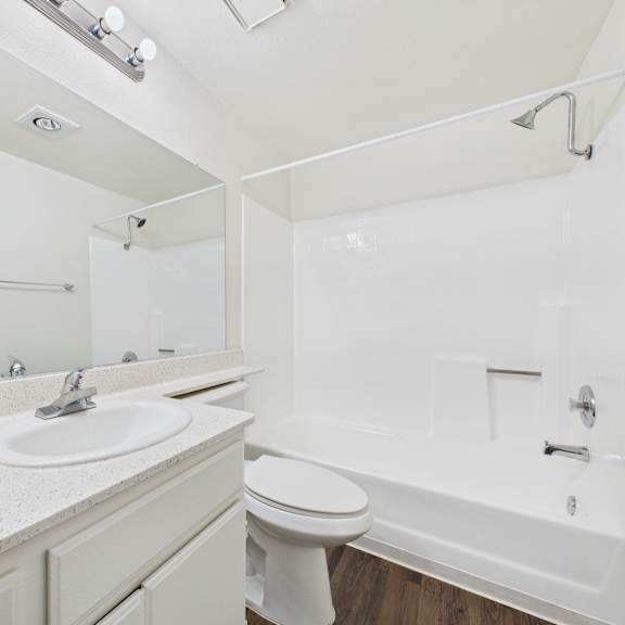 a white bathroom with a sink, toilet, and bathtub.