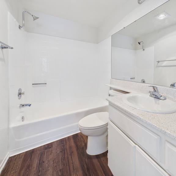 a white bathroom with a toilet, sink, and bathtub.