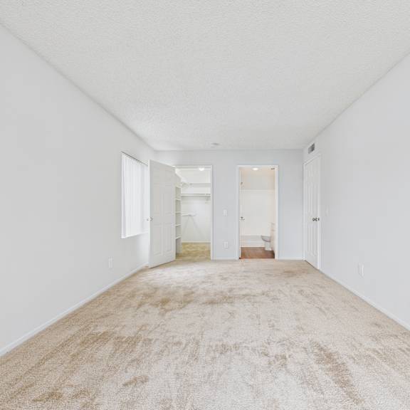a long, empty hallway with carpeted floors and white walls.