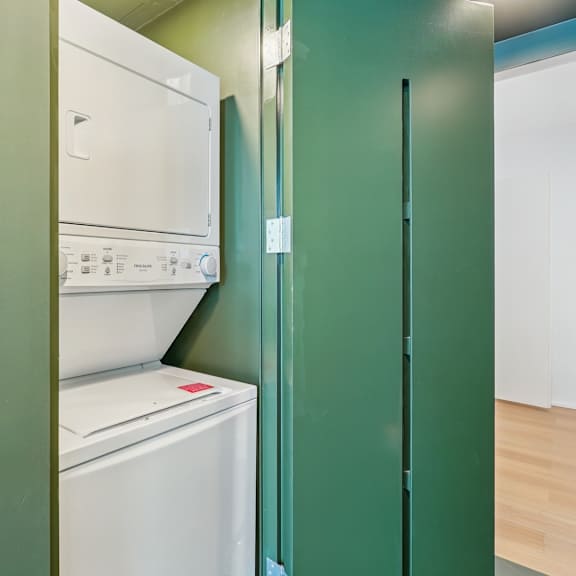 a white dishwasher is in a green cabinet.