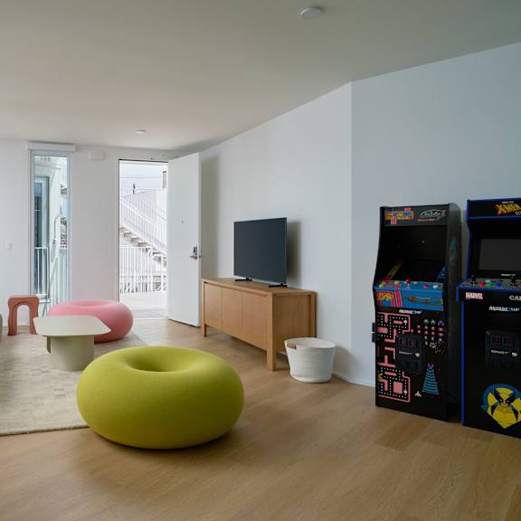 a living room with a yellow bean bag chair and a wooden floor.