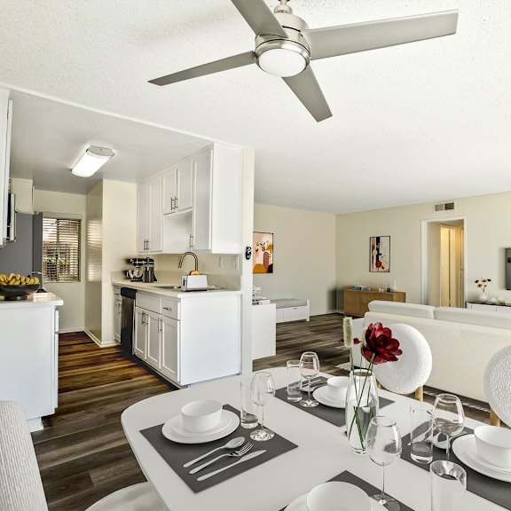 a living room and dining room with a table and a ceiling fan