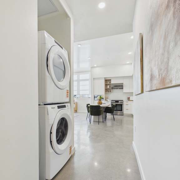 a modern laundry room with a washer and dryer stacked on top of each other.