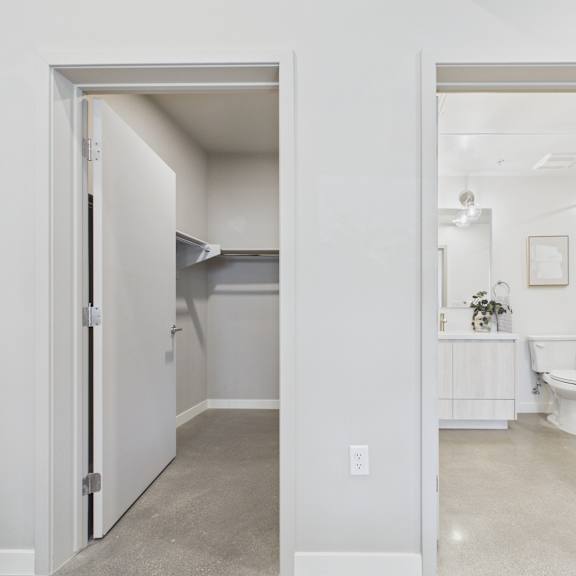 a white bathroom with a toilet, sink, and mirror.