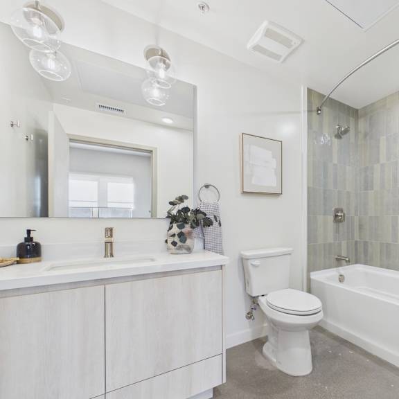 a white bathroom with a toilet, sink, and bathtub.