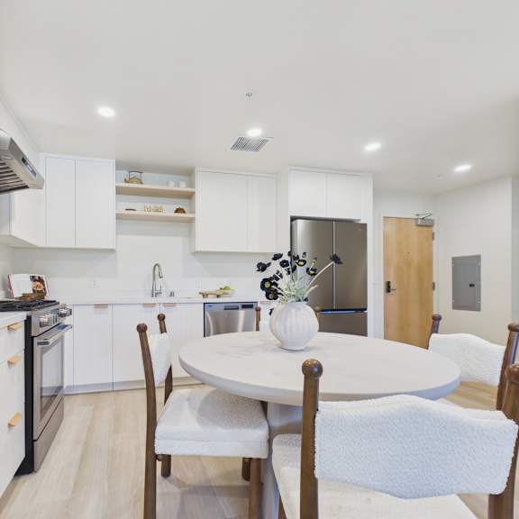 a modern kitchen with a dining table set for four.