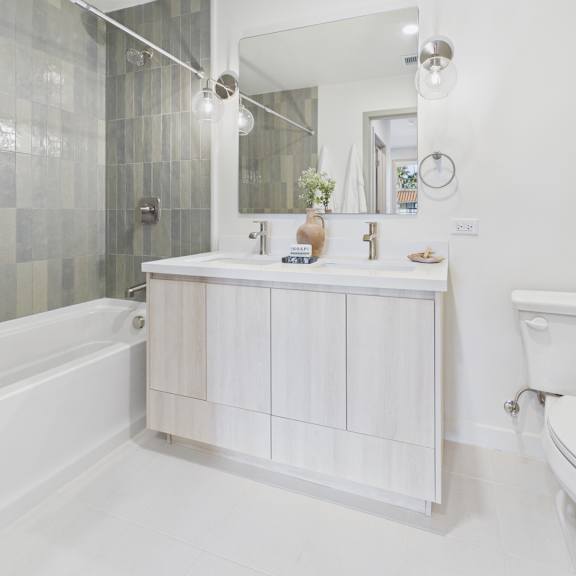 a white bathroom with a white tub, sink, and toilet.