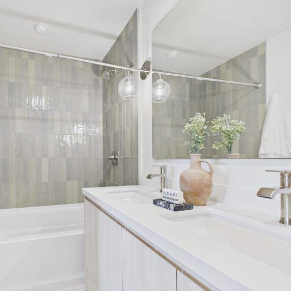 a white bathroom with a tub, sink, and shower.