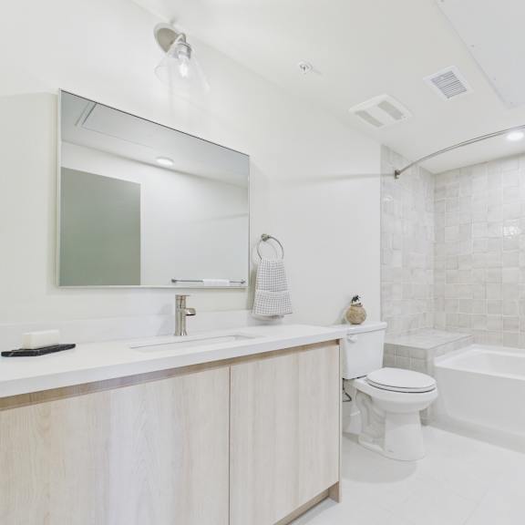 a white bathroom with a tub, toilet, and sink.