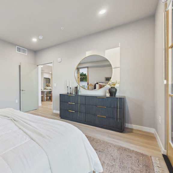 a bedroom with a large bed and a dresser with a mirror.