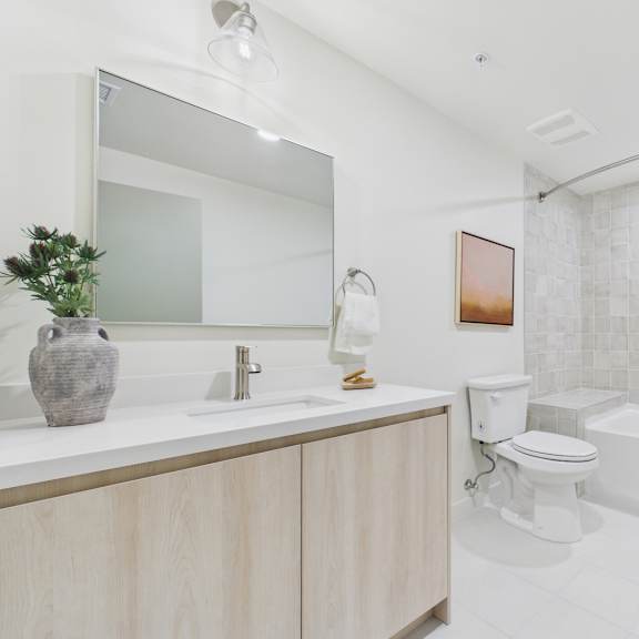 a white bathroom with a sink, toilet, and bathtub.
