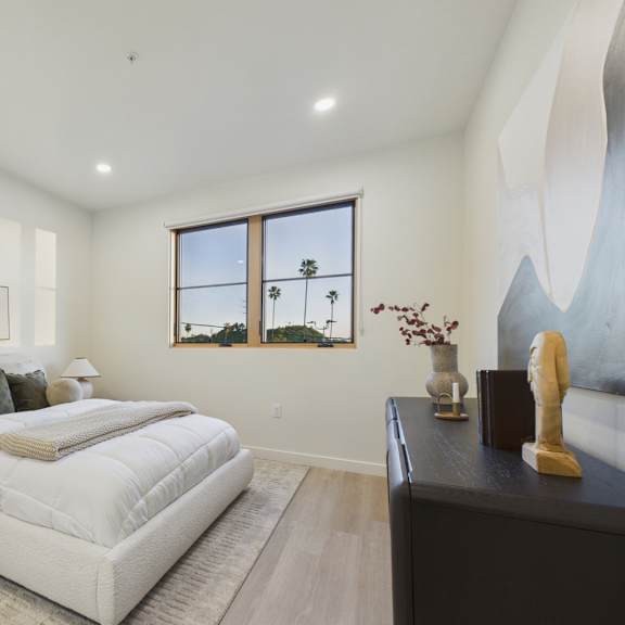 a bedroom with a large bed and a painting on the wall.