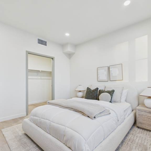 a bedroom with a large bed and a nightstand with a lamp.