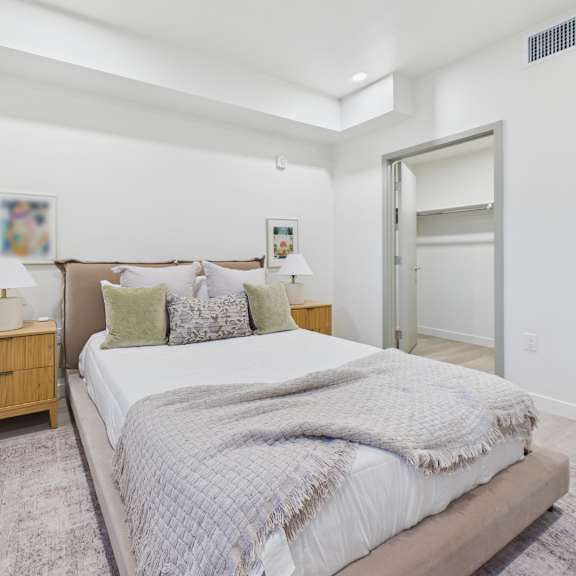a bedroom with a large bed and a wooden nightstand.